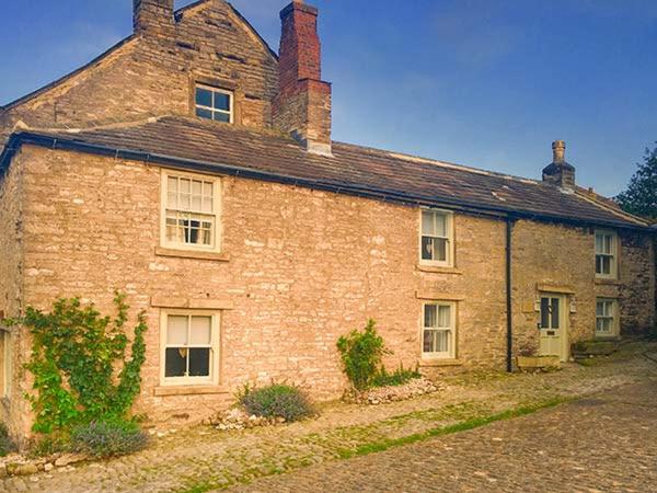 ミドルハムにあるCastle Hill Cottageの窓と屋根のある古いレンガ造りの建物