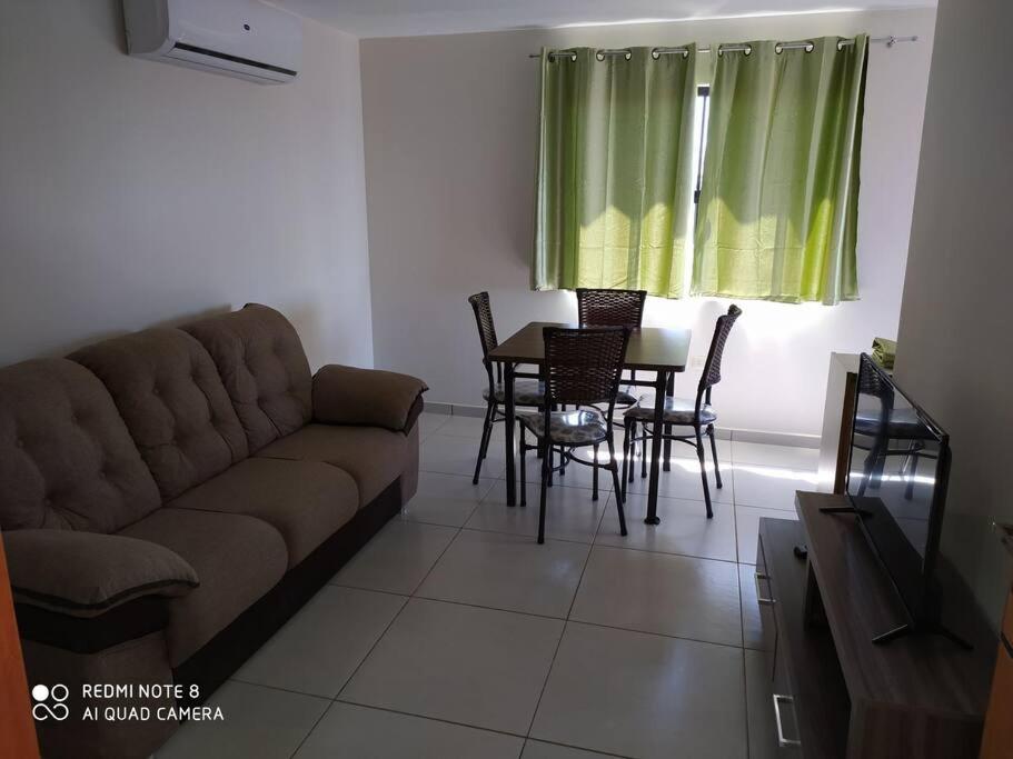 a living room with a couch and a table and chairs at Apart 2 habitaciones vista a Itaipú - 32 in Ciudad del Este