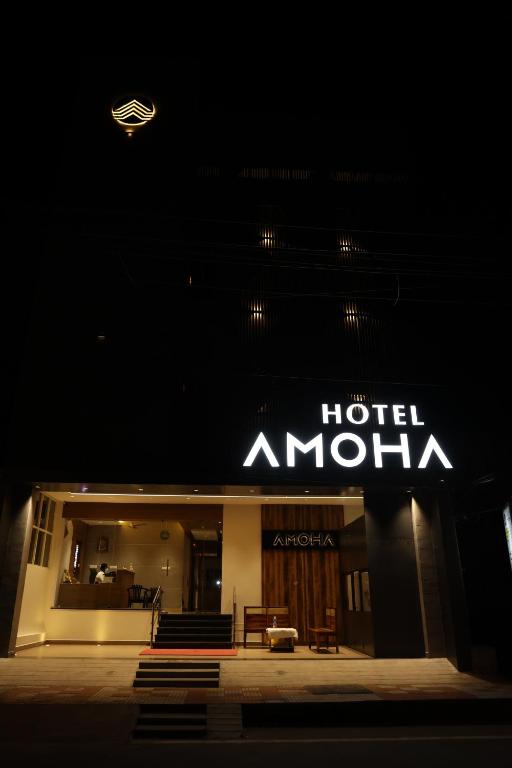Un cartel de hotel amazon en un edificio por la noche en Hotel Amoha, en Palani