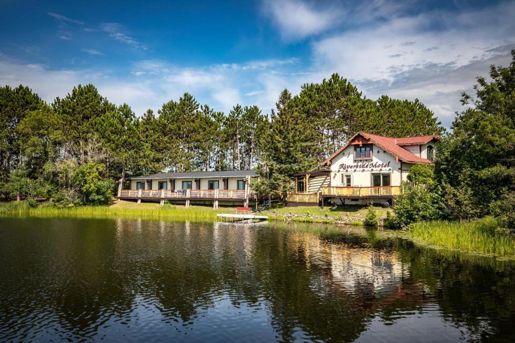 a house on the shore of a lake at Riverside Motel in Hayward