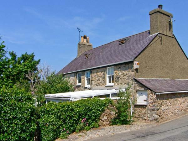 een groot stenen huis met een zwart dak bij Dolfor in Nefyn