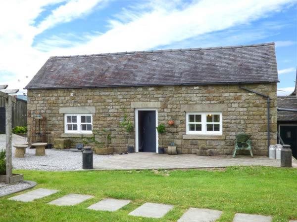 a stone house with a door and a patio at Little Owl Barn in Warslow