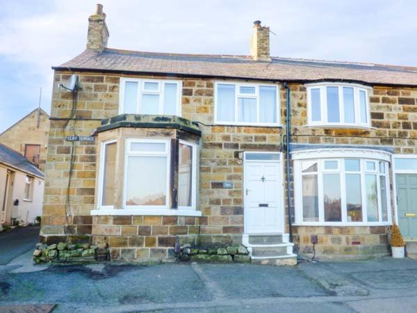 a brick house with white doors and windows at Smugglers' Cottage in Marske-by-the-Sea