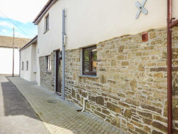 a brick wall of a building next to a street at Sunnymead Cottage in Halwill