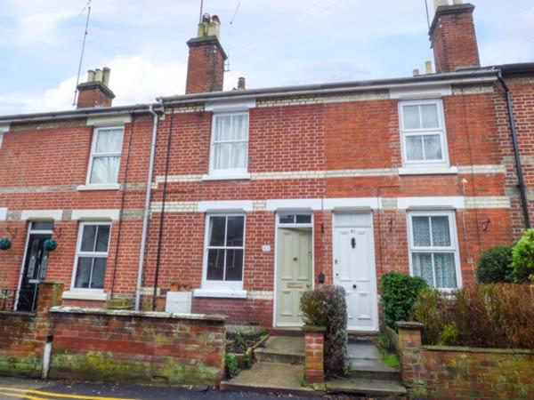 a red brick house with a white door and windows at Dutch Cottage in Colchester