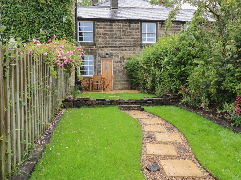 a garden with a stone fence and a house at Riber View in Matlock