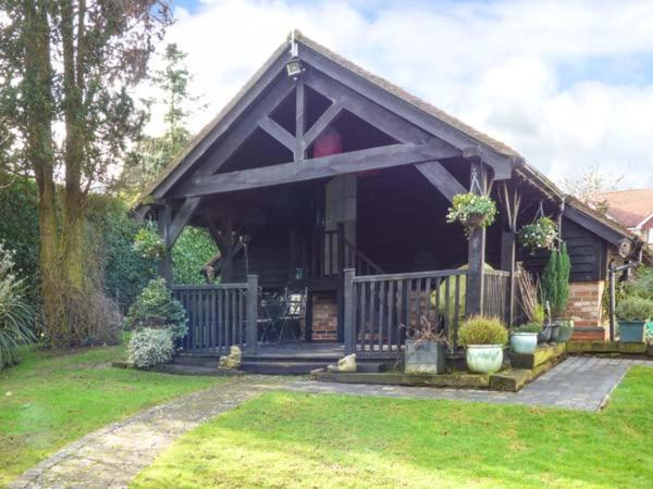 una casa con techo de gambrel y porche en Studio at Little Trees Farm, en Kingsbourne Green