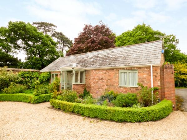 una casa de ladrillo con un jardín delante de ella en The Packing House, en Severn Stoke