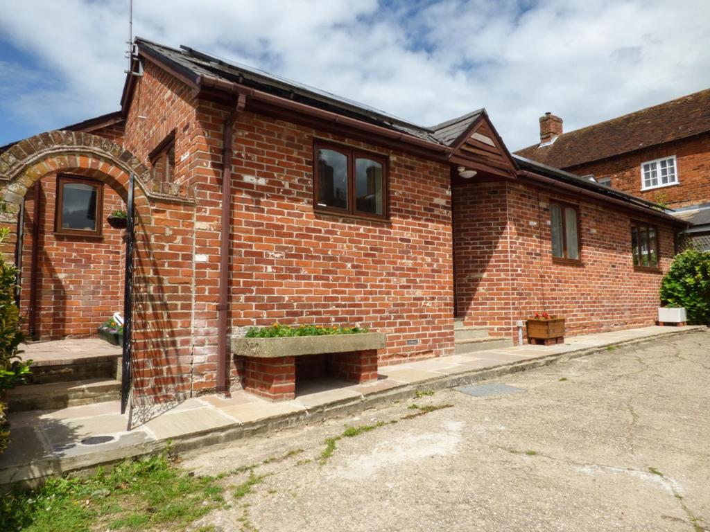 a brick house with a bench in front of it at 27 Swan Street in Boxford