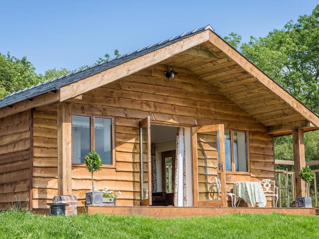 a log cabin with a porch and a door at Stoney-Brook Lodge in Farden