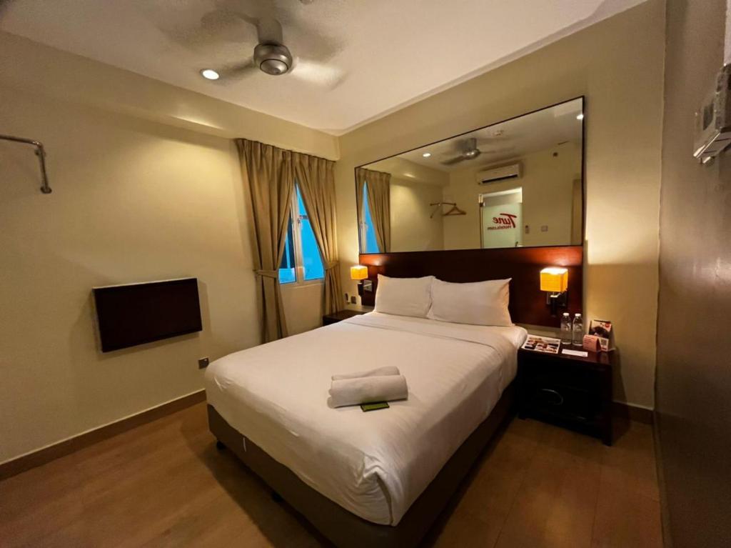a bedroom with a large bed and a mirror at Tune Hotel Georgetown Penang in George Town