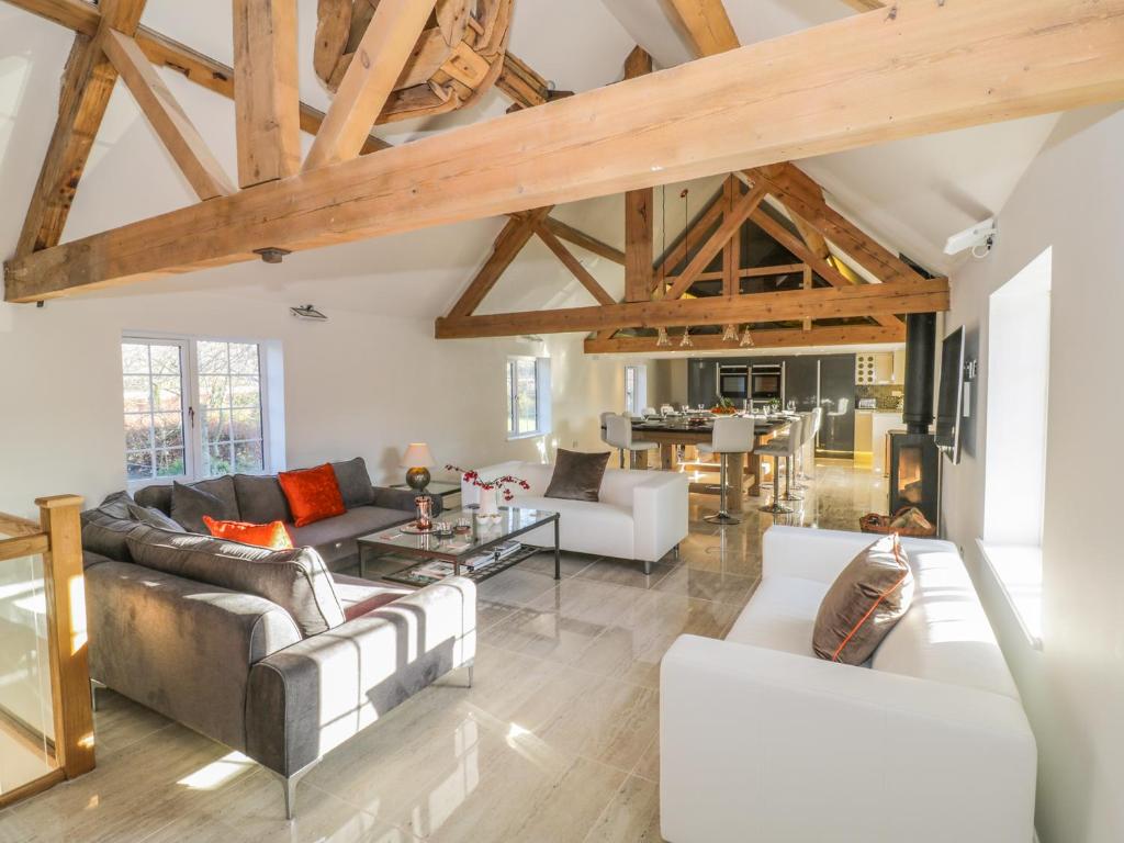 Elle comprend un salon doté d'un mobilier blanc et de plafonds en bois. dans l'établissement Lower Tundridge Cottage, à Suckley