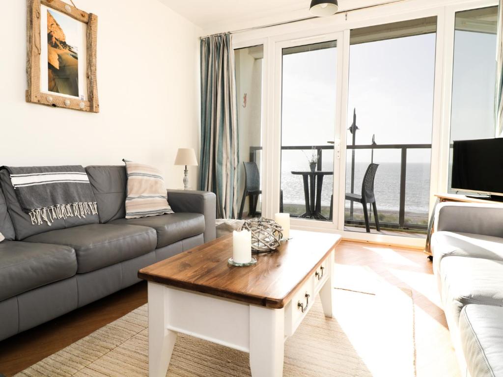 a living room with a couch and a coffee table at 12 West End Point in Pwllheli