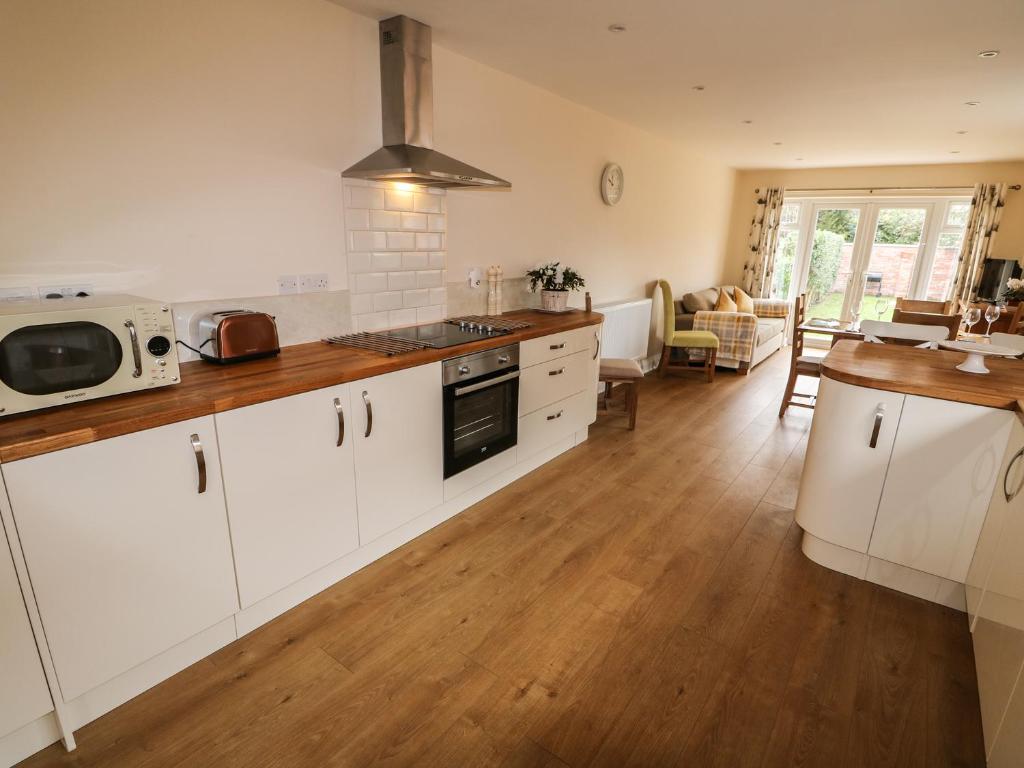 a kitchen with white cabinets and a counter top at Nuholme in Stalham