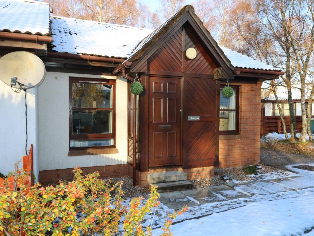 アビモアにあるFoinavenの雪中の木製の扉のある小さな家