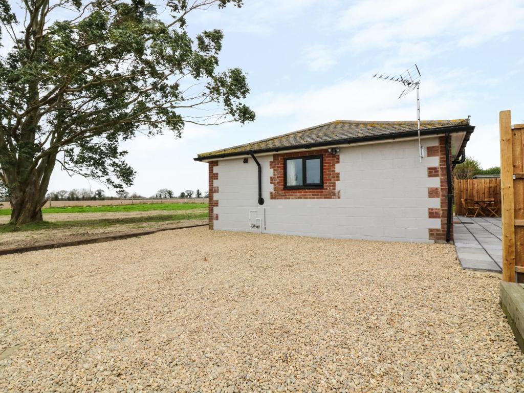 a cottage with a gravel driveway in front of it at The Stable at Church Farm House in Cantley