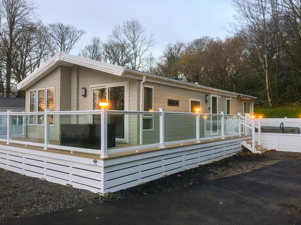 a mobile home with a large deck on a lot at Woodstock Lodge in Skelmorlie