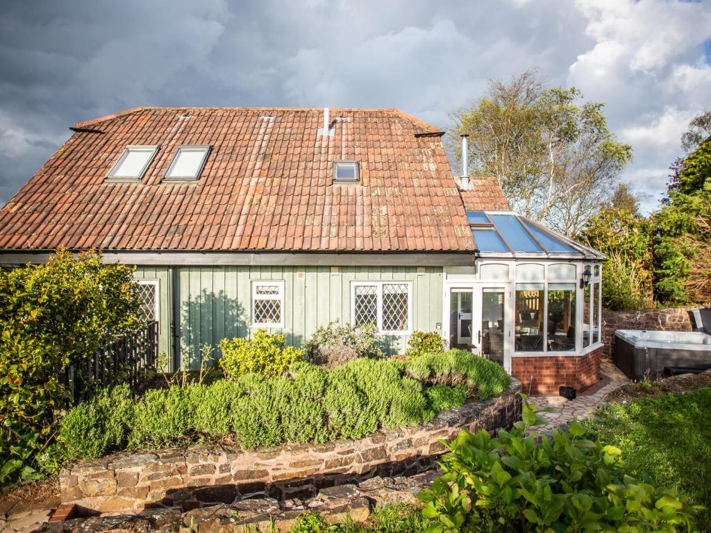 a house with a red roof and a garden at Fig Tree Cottage in Cadeleigh