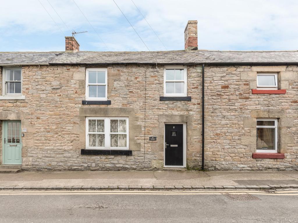 an old brick house on the side of a street at Fisherman's Cottage in Seahouses