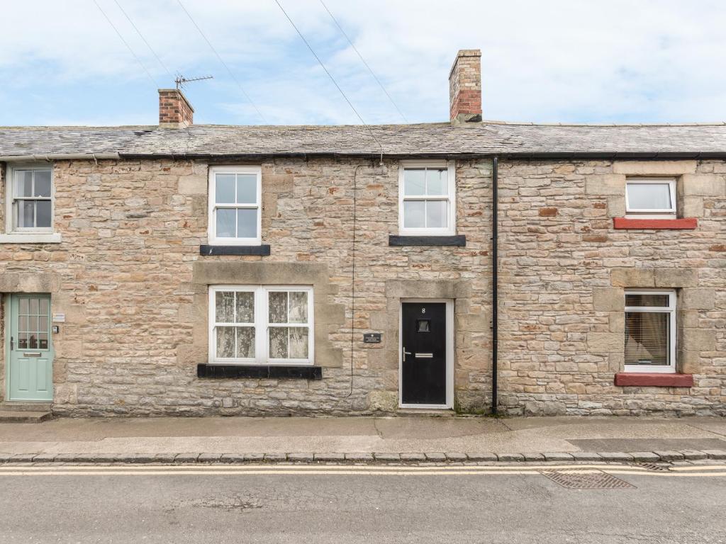 an old brick house on the side of a street at Fisherman's Cottage in Seahouses
