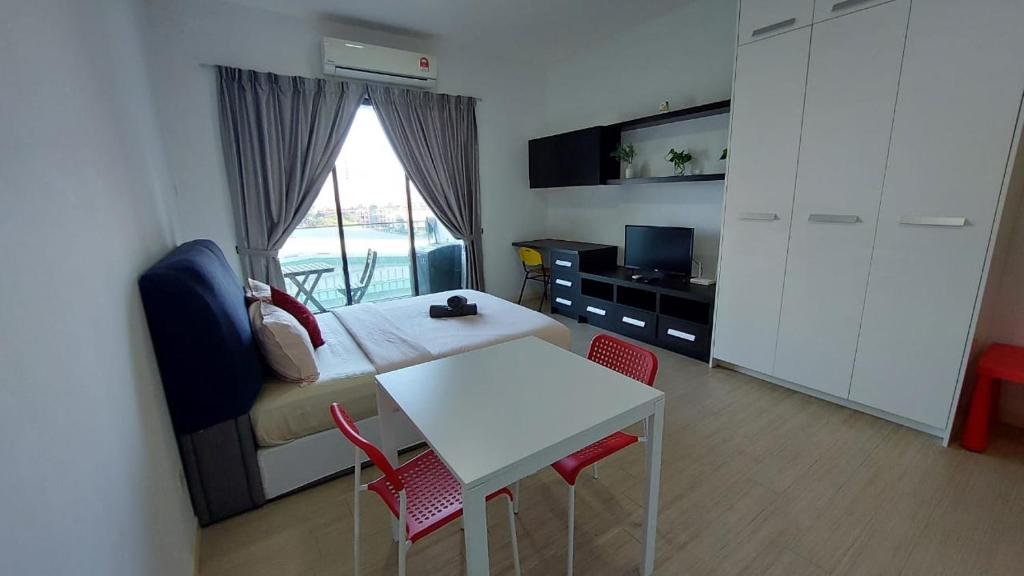 een slaapkamer met een bed en een tafel en stoelen bij Inspired Homes @ PJ Grand Sofo#7 in Petaling Jaya