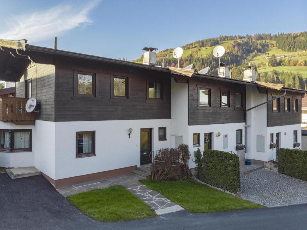 Casa grande de color blanco y marrón con patio en Fleckalm en Kirchberg in Tirol