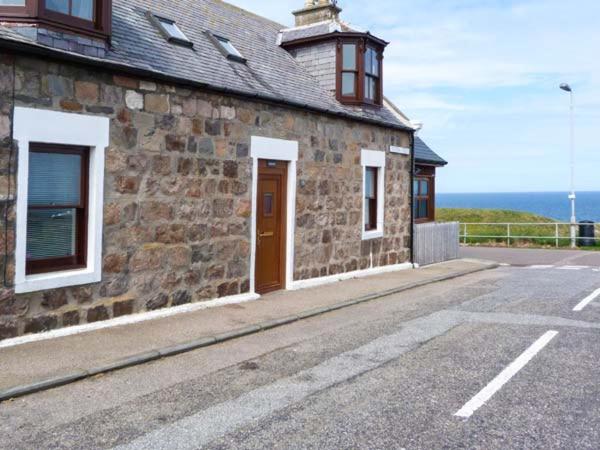 a stone building on the side of a road at Seascape in Buckie