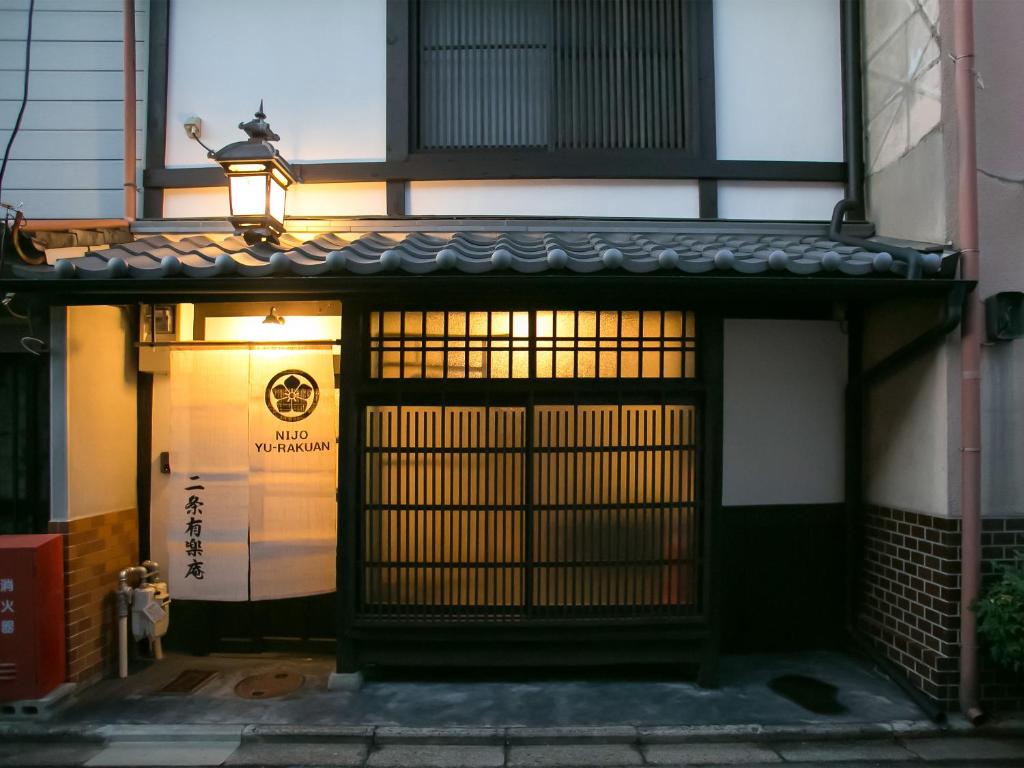 una entrada a un edificio con una puerta y una lámpara en Nijo Yurakuan, en Kioto