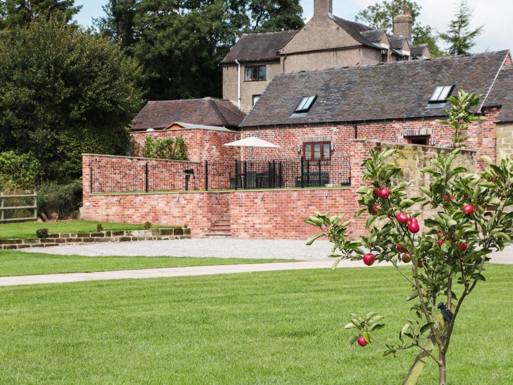 einem Apfelbaum vor einem Backsteingebäude in der Unterkunft Manor Barn in Fulford