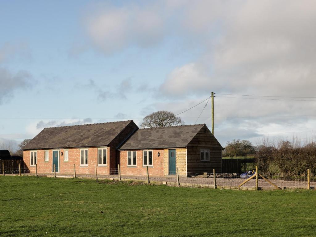 een stenen huis in een veld naast een veld bij Swallow Barn in Walford