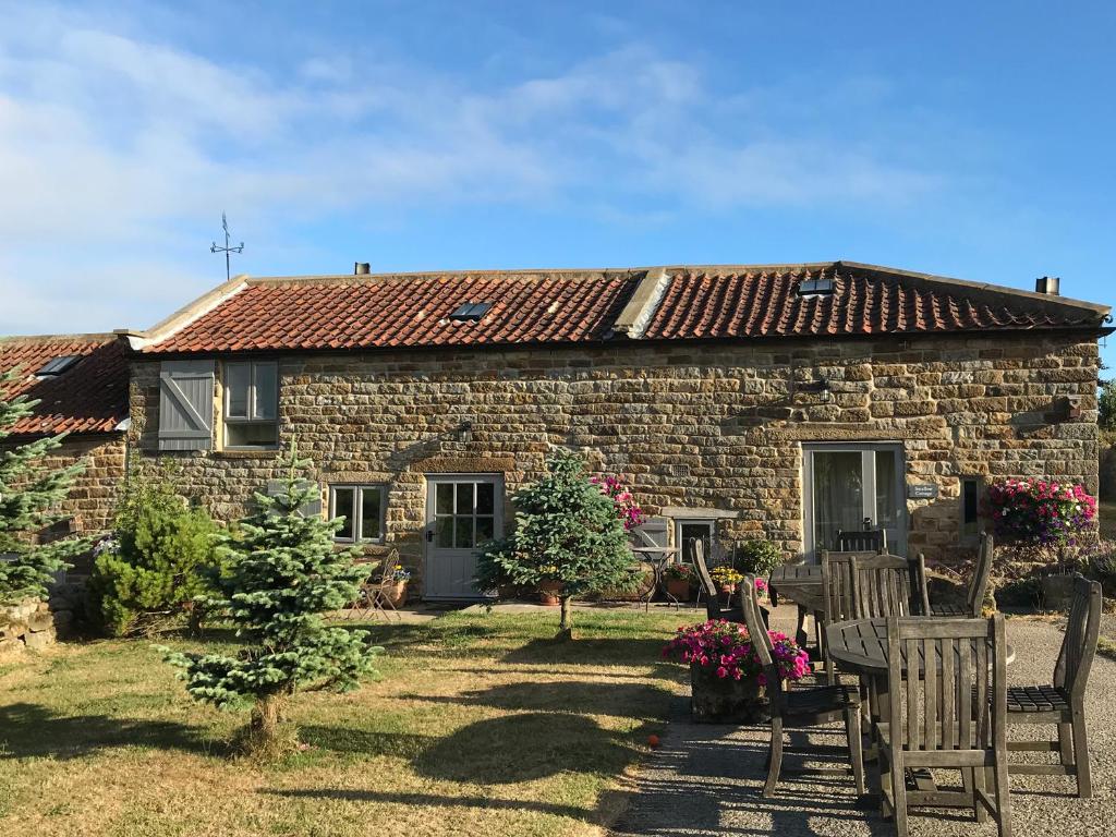 a stone house with two chairs in front of it at Swallow Cottage in Scarborough