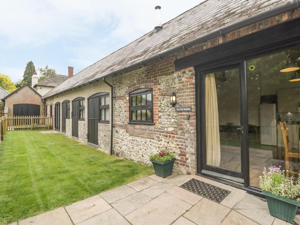 an extension to a brick house with a garden at The Old Stables in Blandford Forum
