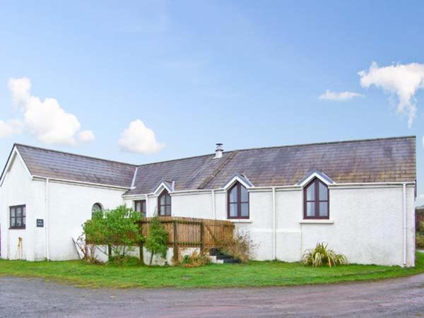 a large white house with a black roof at The Forge in Saint Ishmaels