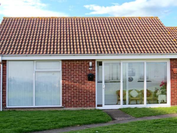 een rood bakstenen huis met glazen schuifdeuren erop bij Sunrise in Lowestoft