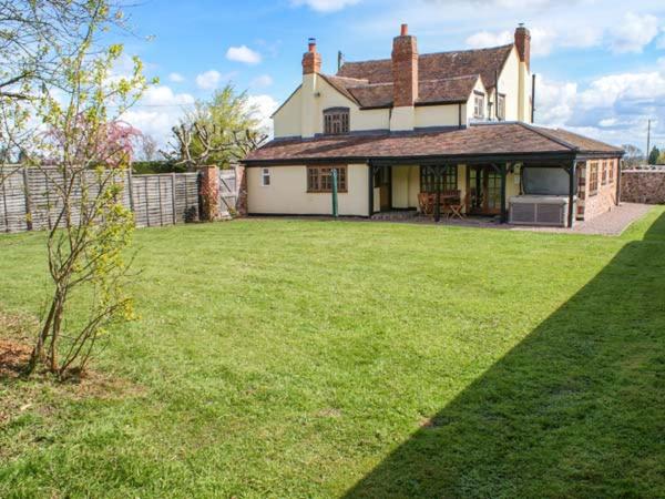 a house with a large yard with a grass yard at Brambles Cottage in Great Malvern