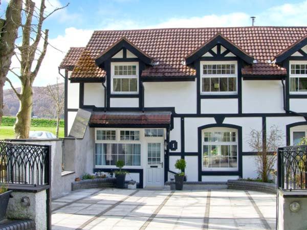 a large black and white house with a driveway at Mountain View in Conwy