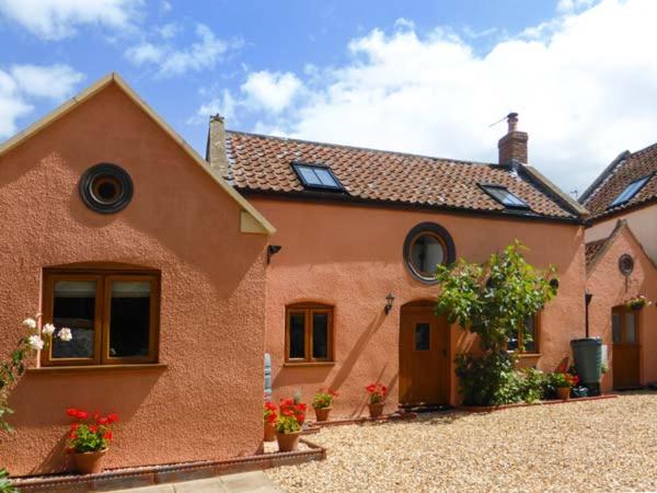 a brick house with flowers in front of it at The Old Stable in Weston-super-Mare