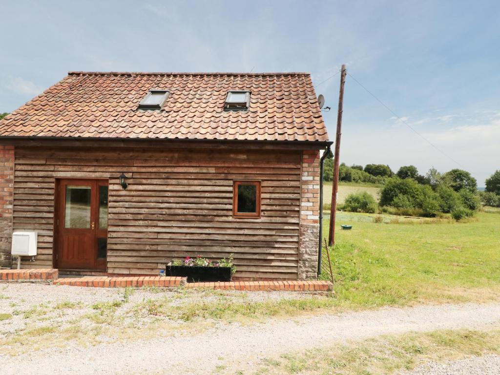 mały drewniany dom z drzwiami i polem w obiekcie Mallard w mieście Newnham