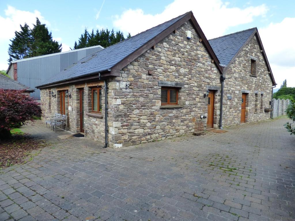 un antiguo edificio de piedra con entrada de ladrillo en Longside, en Abergavenny