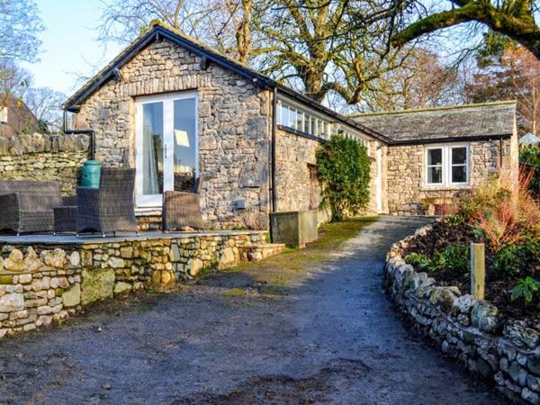 a stone house with a pathway leading to it at The Potting Shed in Carnforth