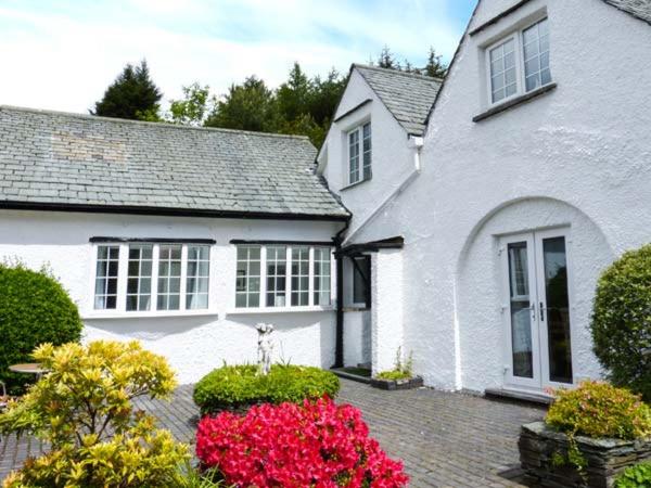 a white house with flowers in front of it at The Nook in Windermere