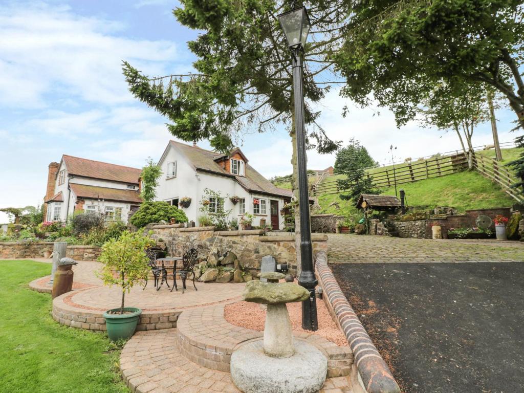 a garden with a stone fountain in front of a house at White Cottage in Hopton Wafers