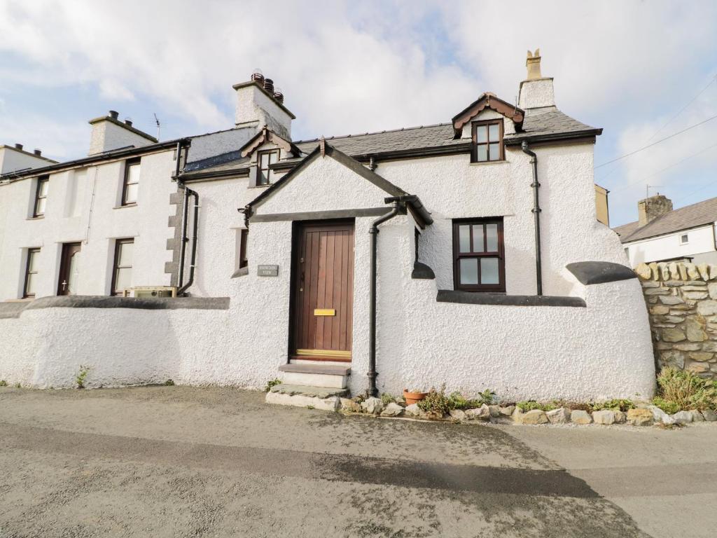 a white brick house with a wooden door at Snowdon View in Holyhead