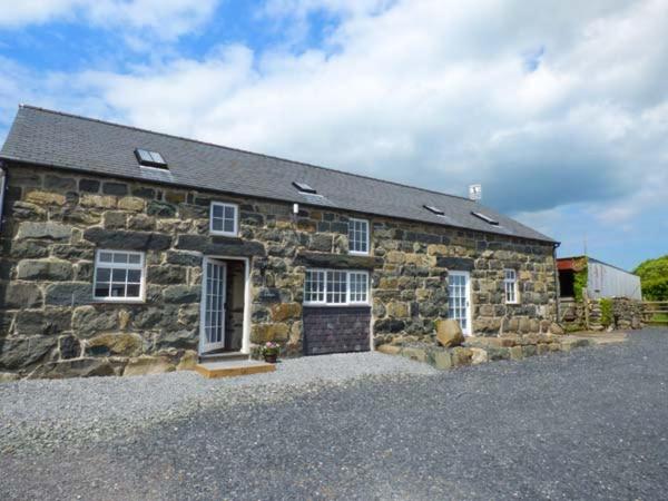 a stone building with a large driveway in front of it at Y Stabal in Chwilog