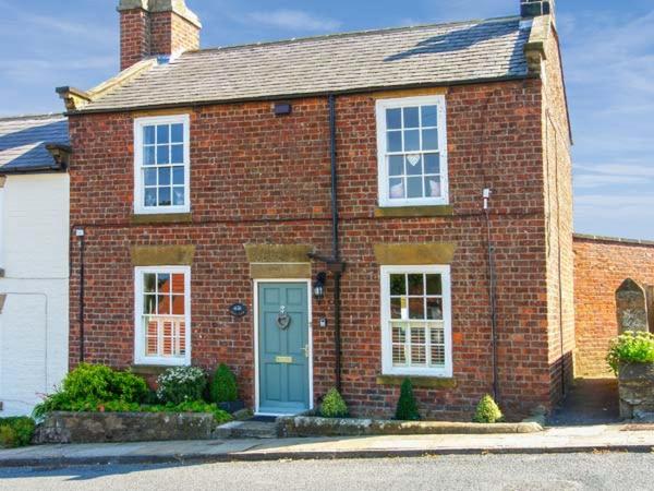 a red brick house with a blue door at Croft View in Whitby