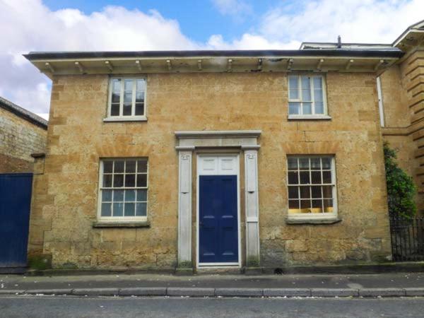 ein Backsteinhaus mit blauer Tür auf einer Straße in der Unterkunft East Wing in Crewkerne