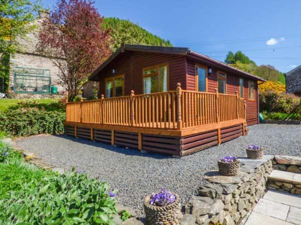 a small wooden cabin with a large deck at North Lodge in Staveley