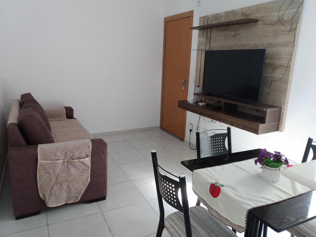 a living room with a couch and a table with a television at Plaza Fraga Maia in Feira de Santana