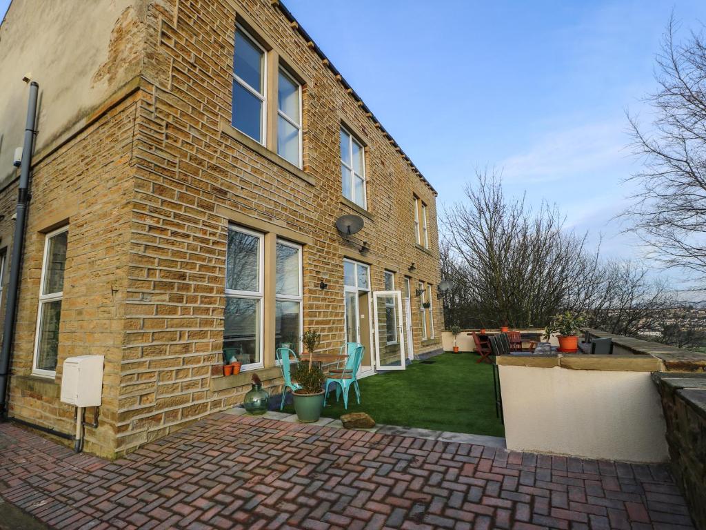 a brick house with a brick patio with two chairs at One Eight Three Guest Cottage in Halifax