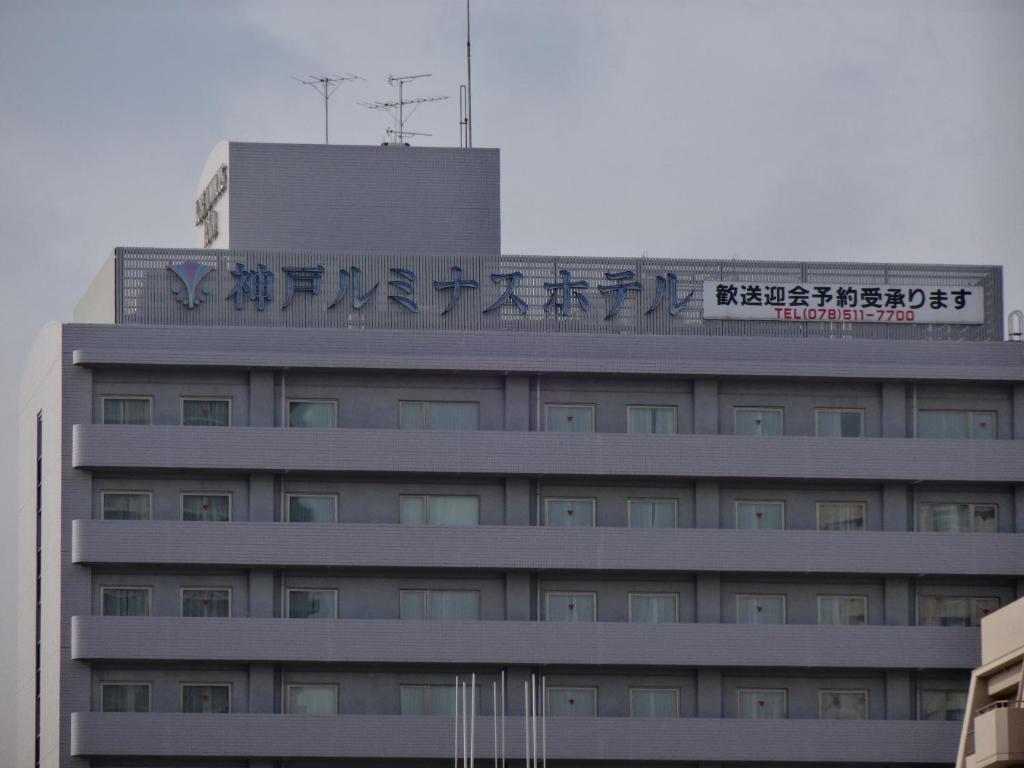 a building with a sign on top of it at Kobe Luminous Hotel in Kobe